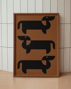 a brown sign with black dogs on it sitting in front of a tiled bathroom wall