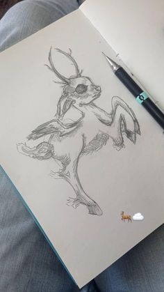 a drawing of a rabbit on paper next to a pen