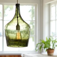 an image of a green light bulb hanging from the ceiling in front of a window