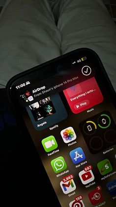 someone is holding an iphone in their hand with the app icons displayed on it's screen