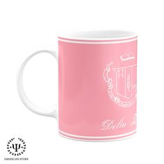 a pink coffee mug with white writing on the bottom and an image of a coat of arms