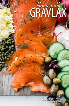 an assortment of vegetables and fish on a cutting board with the words homemade gravlax