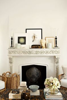 a living room with a fire place and pictures on the fireplace mantel above it