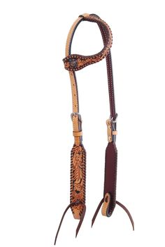 a brown and tan horse bridle with an intricate design on the side,