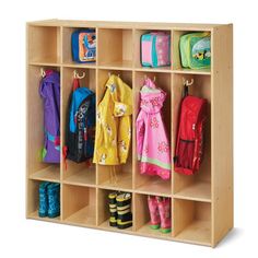 a child's wooden locker with several coats and boots