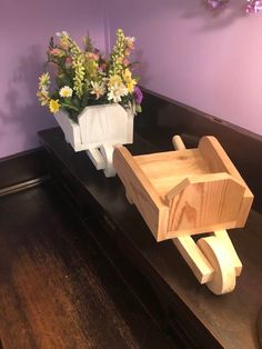 two wooden toys sitting on top of a black table with flowers in the vases