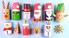 paper roll christmas decorations are lined up on a blue surface with snowmen, santa claus and other holiday items