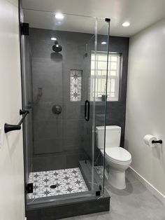 a bathroom with a walk in shower next to a toilet