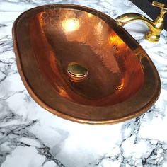 a bathroom sink that is sitting on top of a marble countertop with a gold faucet