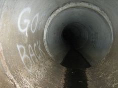 there is graffiti on the side of a pipe