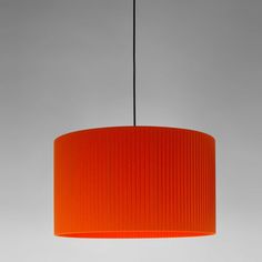 an orange lamp shade hanging from a ceiling