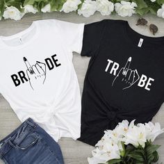 two t - shirts that say bride and groom on them, next to some flowers