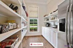 a kitchen with white cabinets and open shelving