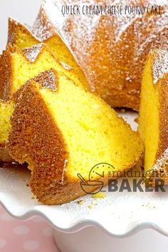 a bundt cake with powdered sugar on top is cut in half and sits on a white plate