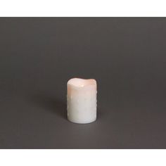 a small white candle sitting on top of a table