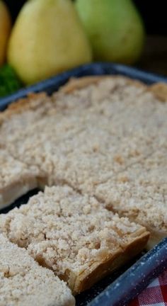 there is a pie that has been cut into pieces and placed on a plate with apples in the background