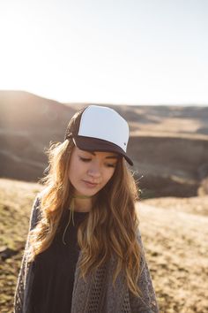 Low profile, white foam, snapback trucker hat with a black bill, and black mesh.