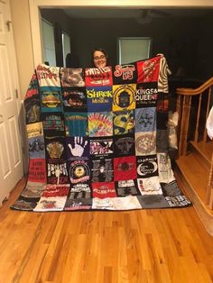 a person sitting on the floor under a blanket made out of t - shirt shirts