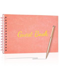 a pink notebook with the words guest book written on it and a pen resting on top