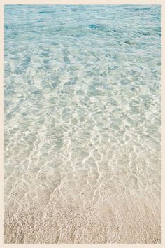 the water is very clear and blue in this beach scene, with white sand on the bottom