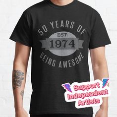 a man wearing a black shirt that says 50 years of being awesome