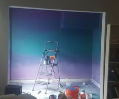 a painting is being done in a room with blue walls and white paint on the floor