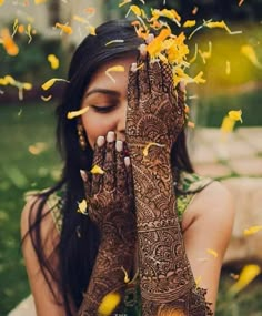 a woman holding her hands up to her face with yellow flowers all over her body