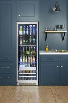 an open refrigerator in a kitchen with blue walls and wooden flooring on the side