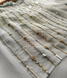 many different types of necklaces laid out on top of each other with gold chains