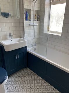 a bathroom with a sink, toilet and bathtub next to a window in it