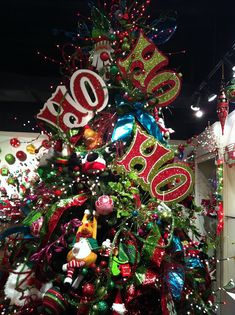 a decorated christmas tree in a store with lots of holiday decorations on it's sides