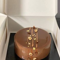 a chocolate cake sitting on top of a black counter next to a white box filled with candy