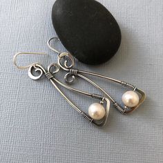 "One of a kind long, oxidized Silver earrings for casual/ business casual wear. The long free form frame is hand formed from Sterling Silver wire and embellished with. 10 mm fresh water Pearl. This is a pair of nice statement earrings for those who are not afraid to stand out:) The earrings are tarnished and tumbled to get this nice antique finish which creates a cool contrast for the white Pearl. They are shipped in a little gift box, ready to be given away, as a present. Dimensions: -total len Elegant White Oxidized Finish Earrings, Pearl Earrings Long, Earrings Long Silver, Silver Wire Earrings, Oxidized Silver Earrings, White Pearl Earrings, Long Silver Earrings, White Pearl Earring, Alloy Earrings