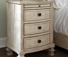 a white nightstand with three drawers and a mirror