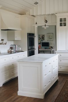 a large kitchen with white cabinets and an island in the middle of the flooring