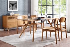 a dining room table with four chairs next to a window