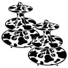 three tiered trays with black and white cow print on the top, each holding two plates