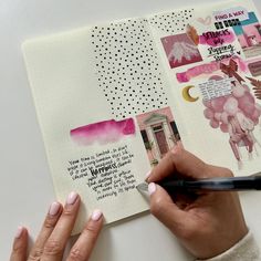 a person holding a pen and writing on top of a page in a planner book