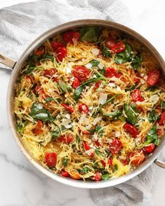 a pot filled with pasta and vegetables on top of a table