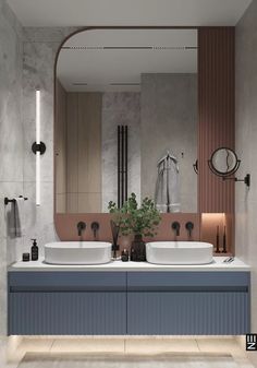 a bathroom with two sinks and a large mirror above the sink, along with a plant in front of it