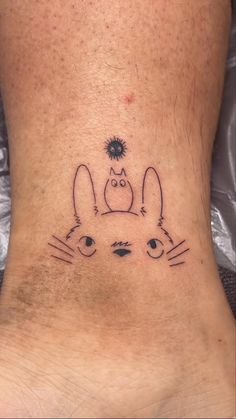 a small tattoo on the back of a person's foot with an image of a cat