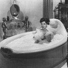 a woman sitting in an old fashioned bath tub