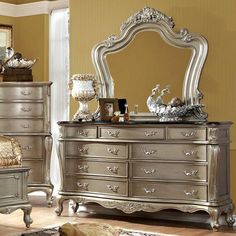 a silver dresser and mirror in a room