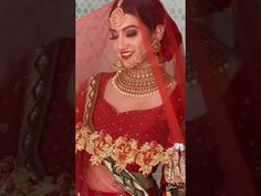 a woman in a red and gold bridal outfit is smiling at the camera while wearing jewelry