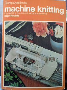 an old sewing machine sitting on top of a table next to a vase with flowers