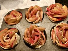 four apple pies sitting on top of a baking pan