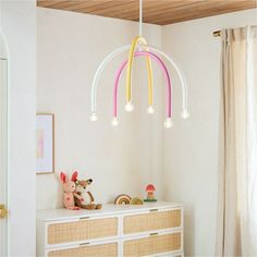 a child's room with toys on the dresser and lights hanging from the ceiling