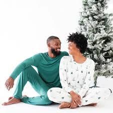 a man and woman sitting in front of a christmas tree