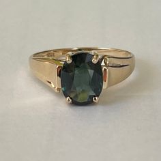 Exquisite 14K Yellow Gold Green Topaz Ring, Size 7.25, 2.58 grams Size: 7.25 Weight: 2.58 grams Main Stone: Green Topaz  Size Stone: ca. xxmm x xxmm Color: Stunning Forest Green Marking: 14K, TRI Gold: Solid 14 Karat Yellow Gold Band Width: ca. xxmm  Tested: PRESIDIUM (C) Duo Tester II, Thermo Scientific Niton DXL Precious Metal Analyzer - tested 14.04KT (testing performed by 3rd party) Condition: Very good preowned- light wear out throughout. Refer to picture for condition. All jewelry will be professionally cleaned before shipping and come in a beautiful little gift box. Returns accepted but are subjected to a 8% restock fee. Returns are only accepted for national orders and in original packaging. Topas Ring, Green Topaz, 3rd Party, Precious Metal, Topaz Ring, Gold Band, Rings Statement, Gold Bands, Little Gifts