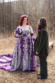 a man standing next to a woman in a purple dress